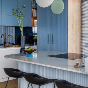 Kitchen interior with marble kitchen island, blue wall, black chokers.